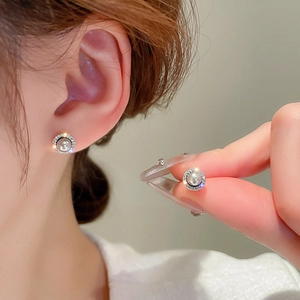 Elegant pearl stud earrings with zircon halo shown being held and worn by a model