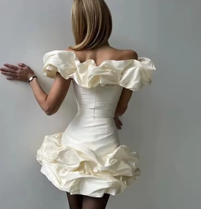 Dettaglio dell'abito in raso bianco con spalle scoperte e balze a strati sul retro