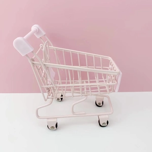 Detailed close-up of a pink mini desktop storage basket with rolling metal wheels