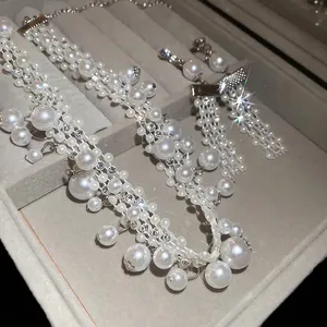 French vintage jewelry set featuring layered pearl necklace and crystal tassel earrings