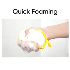 Yellow foam bath sponge with rich lather against a clean white tiled bathroom wall