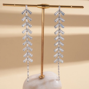 Detailed macro of silver tassel earrings with rectangular cubic zirconia stones