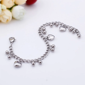 Detail shot of a stainless steel bracelet featuring heart pendants and bead charms