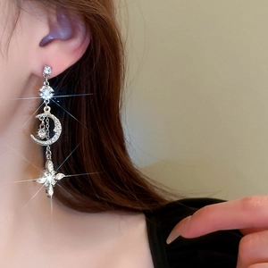 Sparkling silver star and moon tassel earrings with zircon inlay worn by model