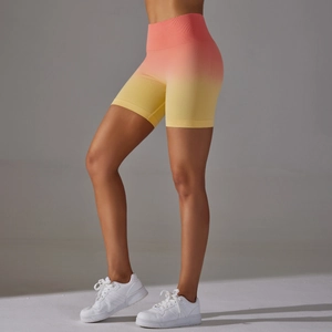 Detailed close-up of high-waisted seamless biker shorts with pink and yellow gradient effect
