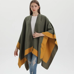 Detail of army green and yellow reversible knit poncho shawl with soft draping texture