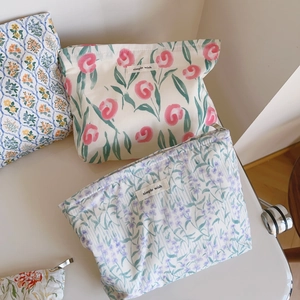 Détail de trousses à maquillage en toile à motifs de roses roses et fleurs mauves