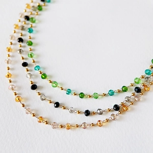 Close-up of three colorful faceted crystal bead necklaces with 18k gold titanium steel chains