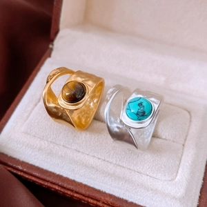 Detail of vintage double-layer open rings with turquoise and tiger eye stone in a jewelry box