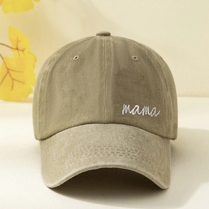 Close-up detail of 'mama' embroidery on washed cotton baseball cap fabric texture