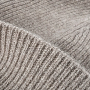 Winter wool knitted beanie hat in oatmeal color with thick ribbed texture for warmth