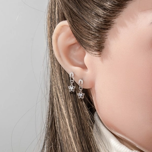 Silver paperclip earrings with star pendant and clear zircon stone on female model
