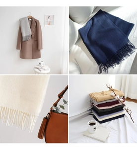 Detail of multi-color cashmere-like scarves with fringe edges in soft lifestyle setting