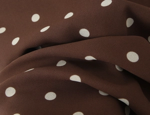 Détail du tissu en mousseline à pois marron café avec texture douce et beau drapé