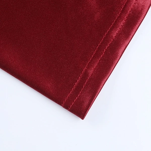 Detail shot of deep red satin dress showing high-quality double needle stitching texture