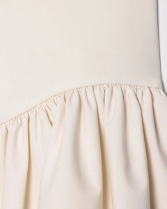 Detailed view of cream-white fabric showing high-quality stitching and pleated texture