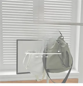 Detail of nylon bucket bags in white and olive green with adjustable straps and drawstring