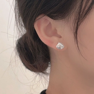 Minimalist 925 sterling silver seashell stud earring on model's ear showing realistic texture