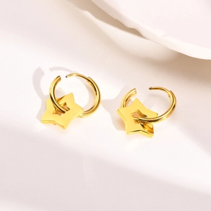 Detail of gold stainless steel hoop earrings with hanging star charms on white background
