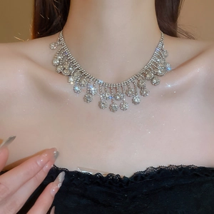 Silver choker necklace with sparkling rhinestones and elegant tassels worn by a model