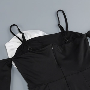 Detail of adjustable straps and back zipper on black dress with white flower accent