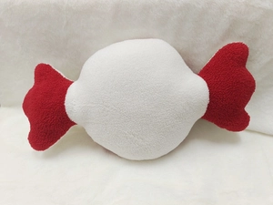 Detailed view of candy shaped Christmas plush pillow in soft red and white fleece fabric
