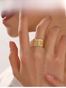 Gros plan d'une bague large dorée œil protecteur avec finition texturée sur main