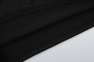 Détail macro de l'ourlet à double couture et texture du tissu en maille noire