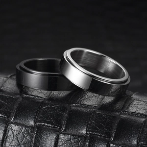 Pair of minimalist rotating titanium steel rings in black and silver on leather