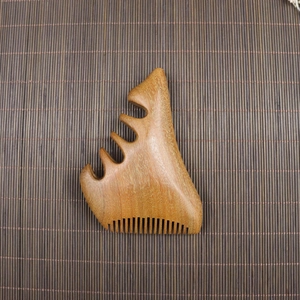 Macro shot of sandalwood scalp massage comb with five polished teeth on bamboo mat