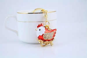 Close-up of golden rooster keychain with sparkling rhinestones and red enamel details
