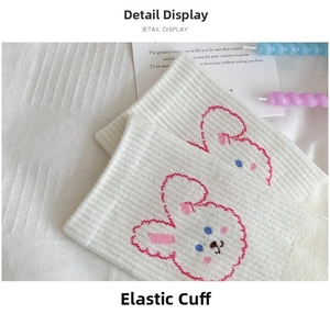 Detail of white cotton socks with cute rabbit embroidery and elastic ribbed cuffs