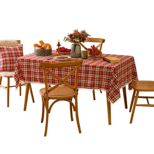 Red plaid Christmas tablecloth with white pom-pom fringe and festive holiday table decor