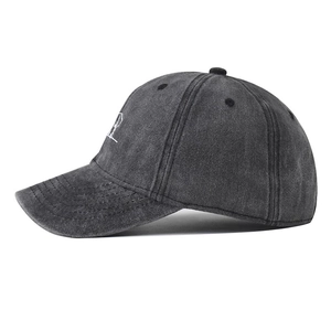 Detail of washed charcoal grey cotton baseball cap showing side stitching and texture