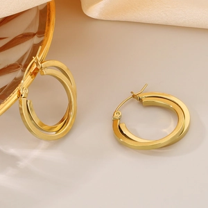 Chic golden double-hoop titanium steel earrings shown with elegant lighting and shadows