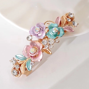 Détail de la pince à cheveux à fleurs en émail avec strass sur base dorée