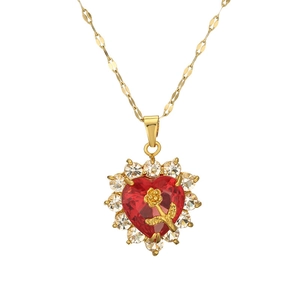 Gold heart necklace with red gemstone and rose engraving on a clean white background
