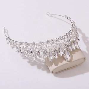 Detailed view of silver bridal tiara with marquise crystals on a beige display stand