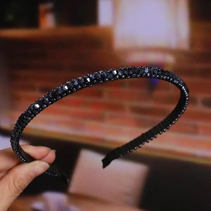 Detail showing hand-held black beaded headband with sparkling faceted crystal beads