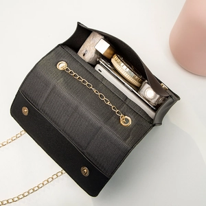 Quilted black crossbody bag with gold chain strap showing spacious inner storage