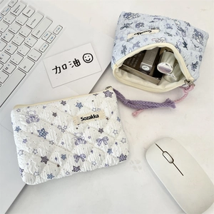 Detailed macro view of two quilted floral cotton cosmetic bags with zip and hand straps