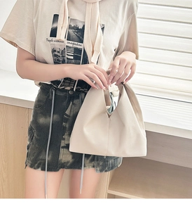 Detail of beige lychee pattern faux leather tote bag showing soft pleated texture