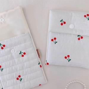 Close-up of quilted cotton cherry print makeup bags showing interior lining and snap button