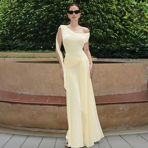 Detail of light yellow maxi dress with elegant pleats and asymmetrical shoulder design