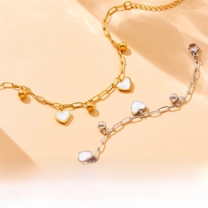 Detail of gold and silver heart charms with white shell inlay and bead chain