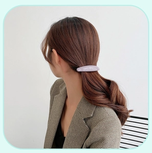 Close-up of matte purple rectangular hair clip worn on a low ponytail ponytail hair