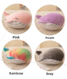 Detailed view of four colorful plush whale keychains in pink, purple, rainbow and grey