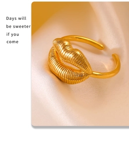 Macro view of gold lip-shaped ring with fine vertical textures on satin background