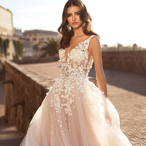 Lace wedding dress with 3D floral appliques and deep V-neck in a sleeveless long style