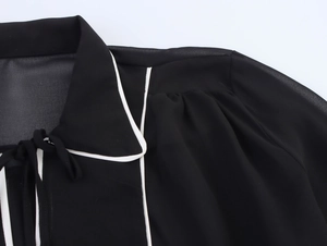 Vue détaillée d'une robe en mousseline avec col polo contrasté, liseré blanc et noeud